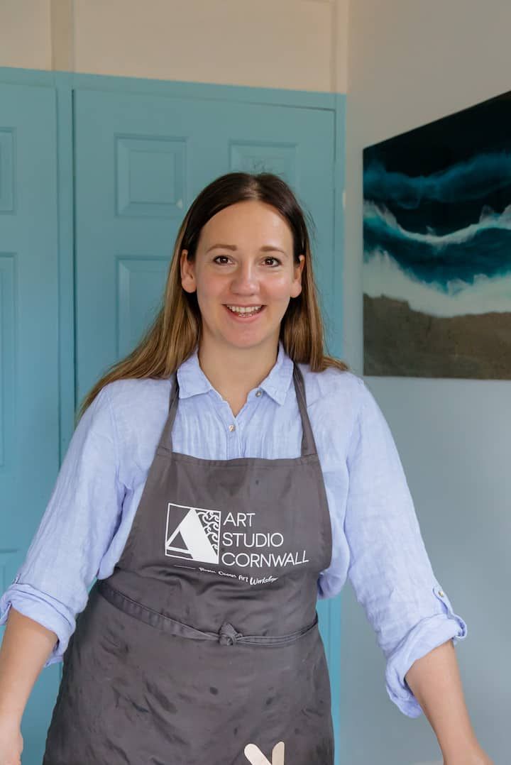 Andrea in her Art Studio Cornwall apron, one of her resin ocean pieces behind her.
