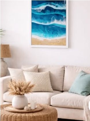 Framed resin ocean artwork — glossy teal waves over real Cornish sand, hung above a cream sofa.