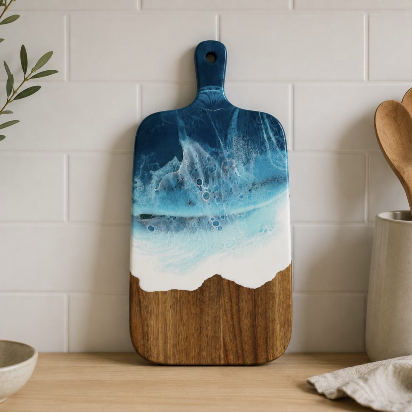 Resin ocean chopping board hung in a kitchen.