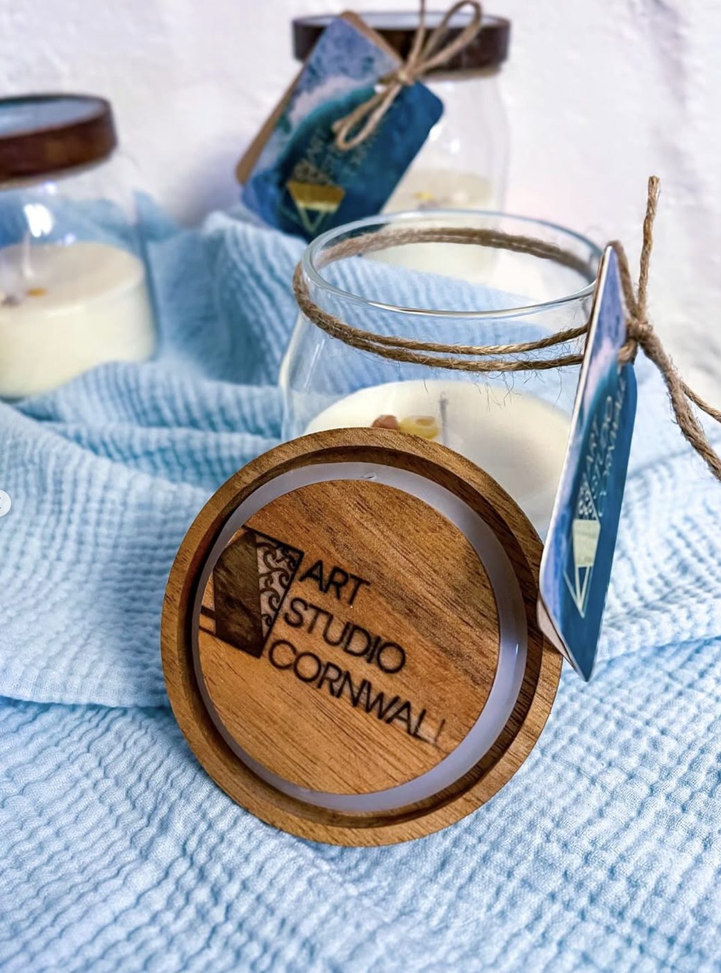 Soy candles with resin-ocean lids, tied with twine.